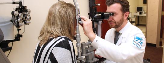Ophthalmologist Dr. Pomykala performing eye exam on patient