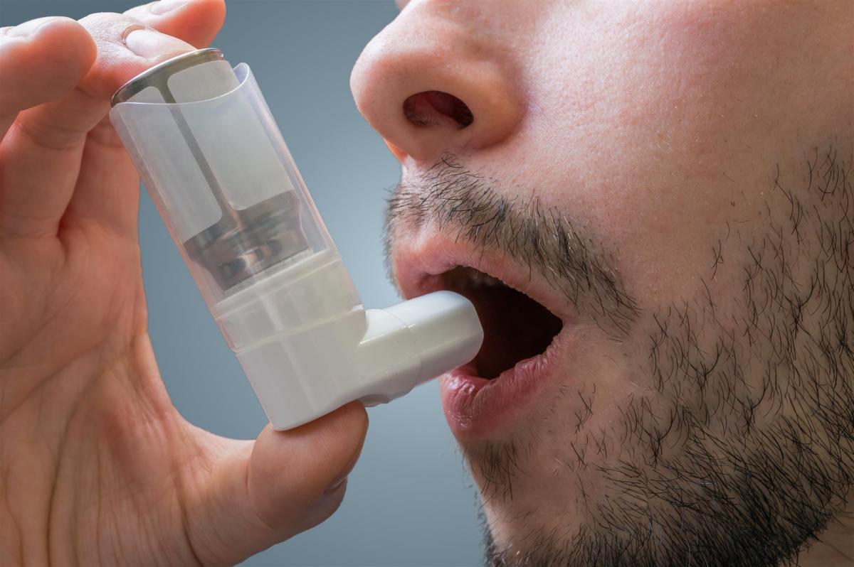 Man using inhaler during asthma