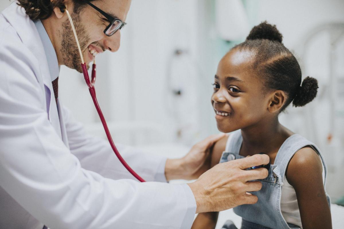 Friendly pediatrician checking a little girls heart