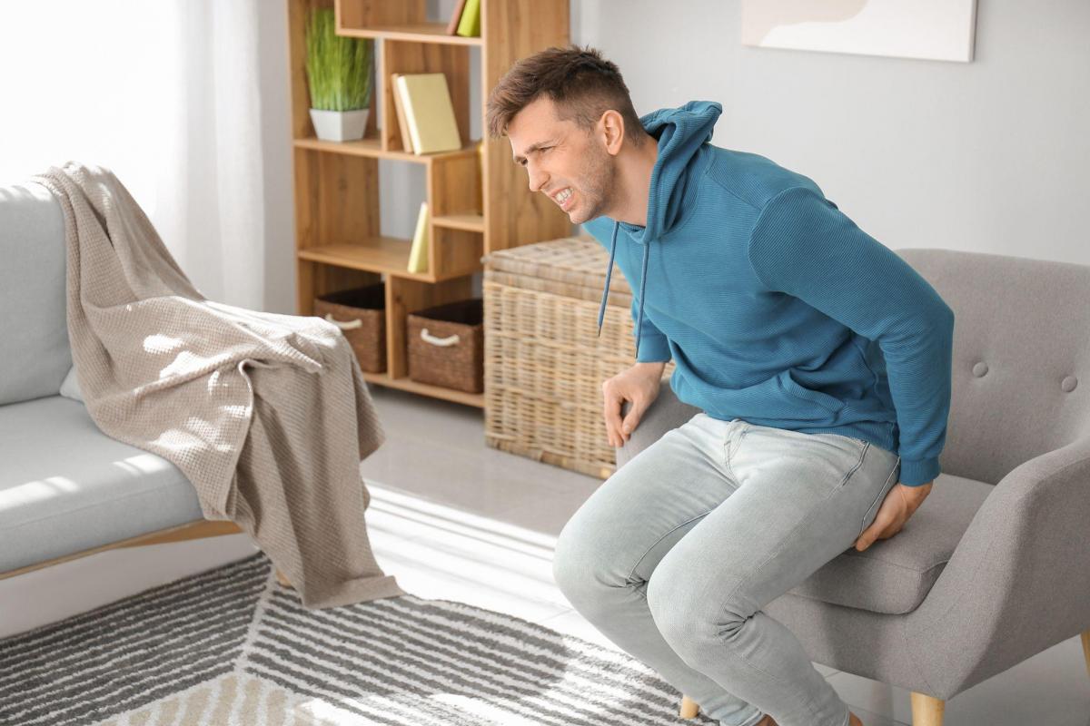young man with hemorrhoids at home