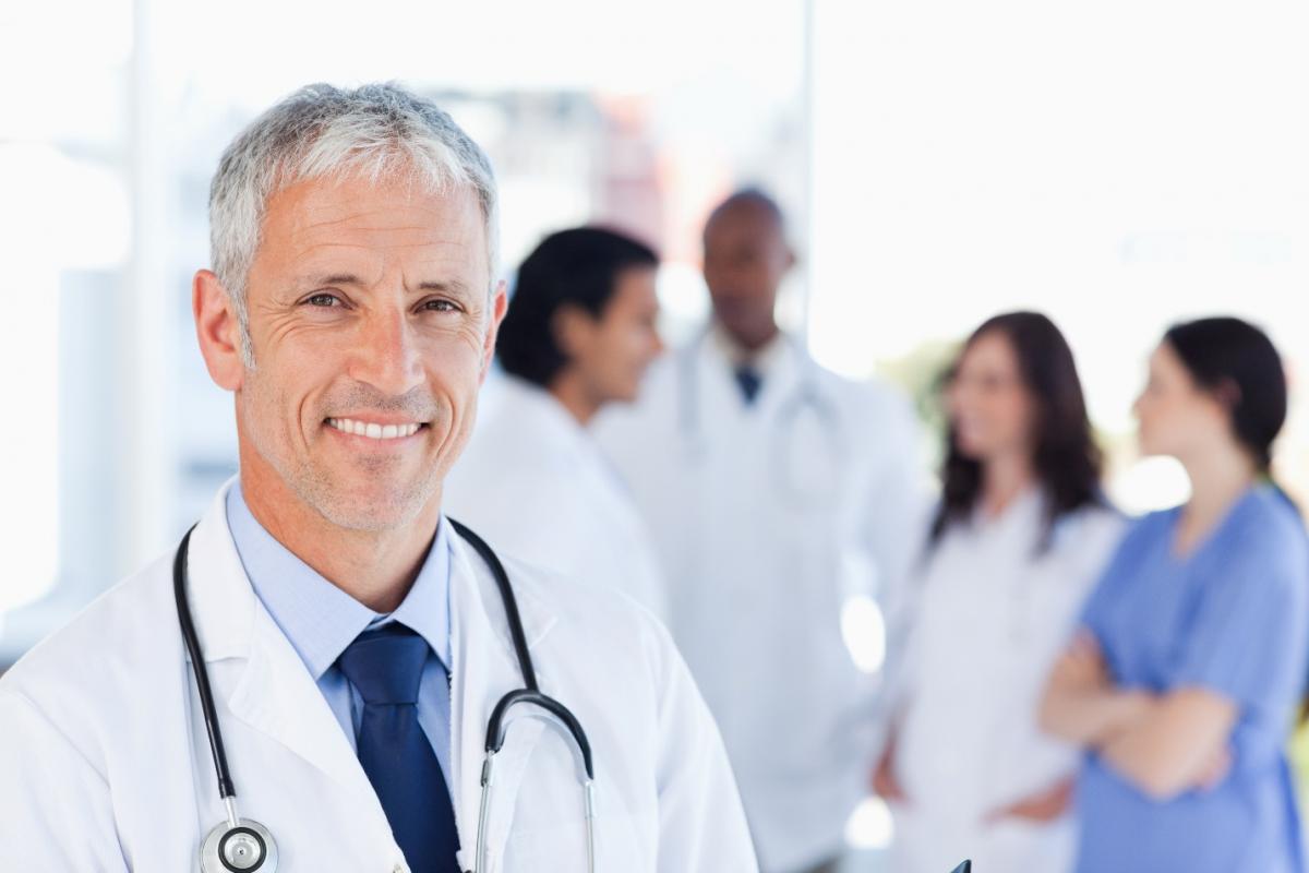smiling doctor waiting for his team while standing upright