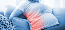 pregnant-woman-suffering-from-backache-on-sofa-at-home