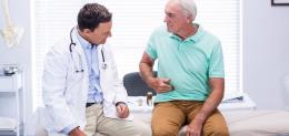 senior-man-showing-stomach-pain-to-doctor