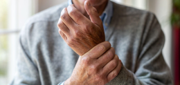 Senior man with arthritis rubbing hands