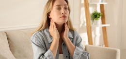 Young woman doing thyroid self examination at home