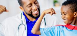 doctor and boy making muscle with arms