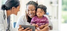 Pediatrician interacts with patient and their parent