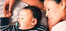 Parent rests alongside their baby