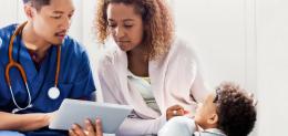A provider discusses information with the parent of a young patient