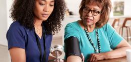 nurse and woman checking blood pressure