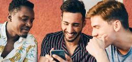 three men looking at mobile phone