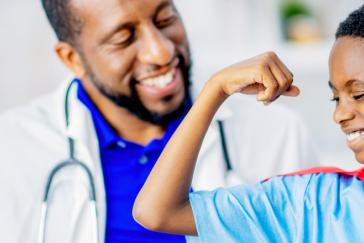 doctor and boy making muscle with arms
