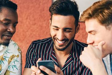 three men looking at mobile phone