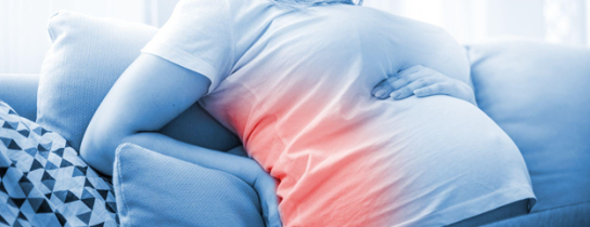 pregnant-woman-suffering-from-backache-on-sofa-at-home
