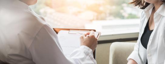 Behavorial health provider holding a clipboard while speaking with a patient