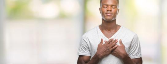 Man with hands held over his chest