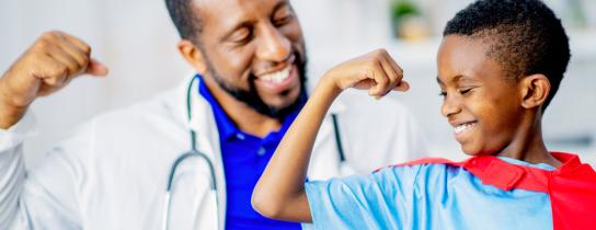 doctor and boy making muscle with arms