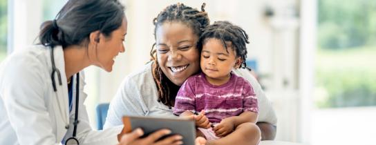 Pediatrician interacts with patient and their parent