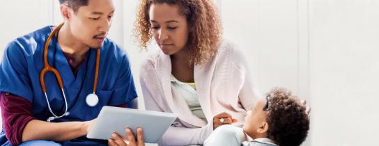 A provider discusses information with the parent of a young patient