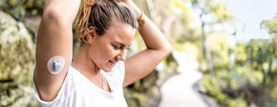 Woman outdoors with a diabetes pump on her arm