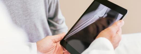 hands holding tablet with xray