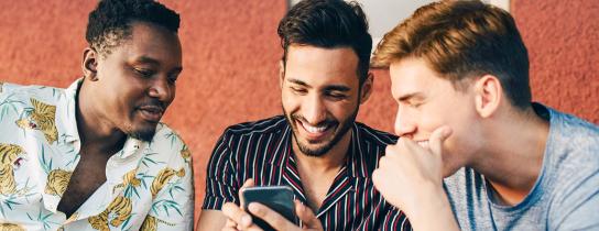 three men looking at mobile phone