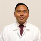 A photo of Rainier Jude Ricanor, MD smiling and wearing a lab coat.