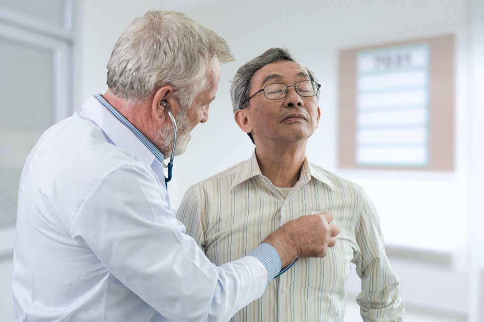 The senior doctor listen the heart of the elderly patient