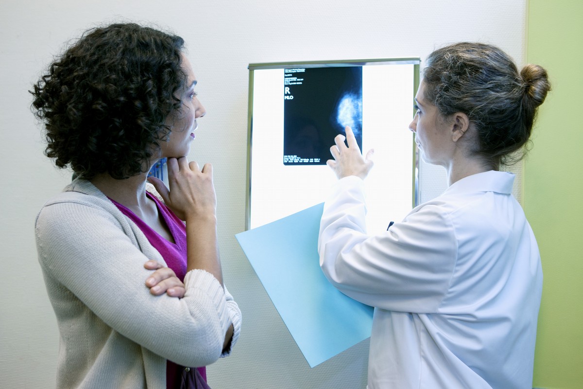 young female doctor pointing to x-ray with patient